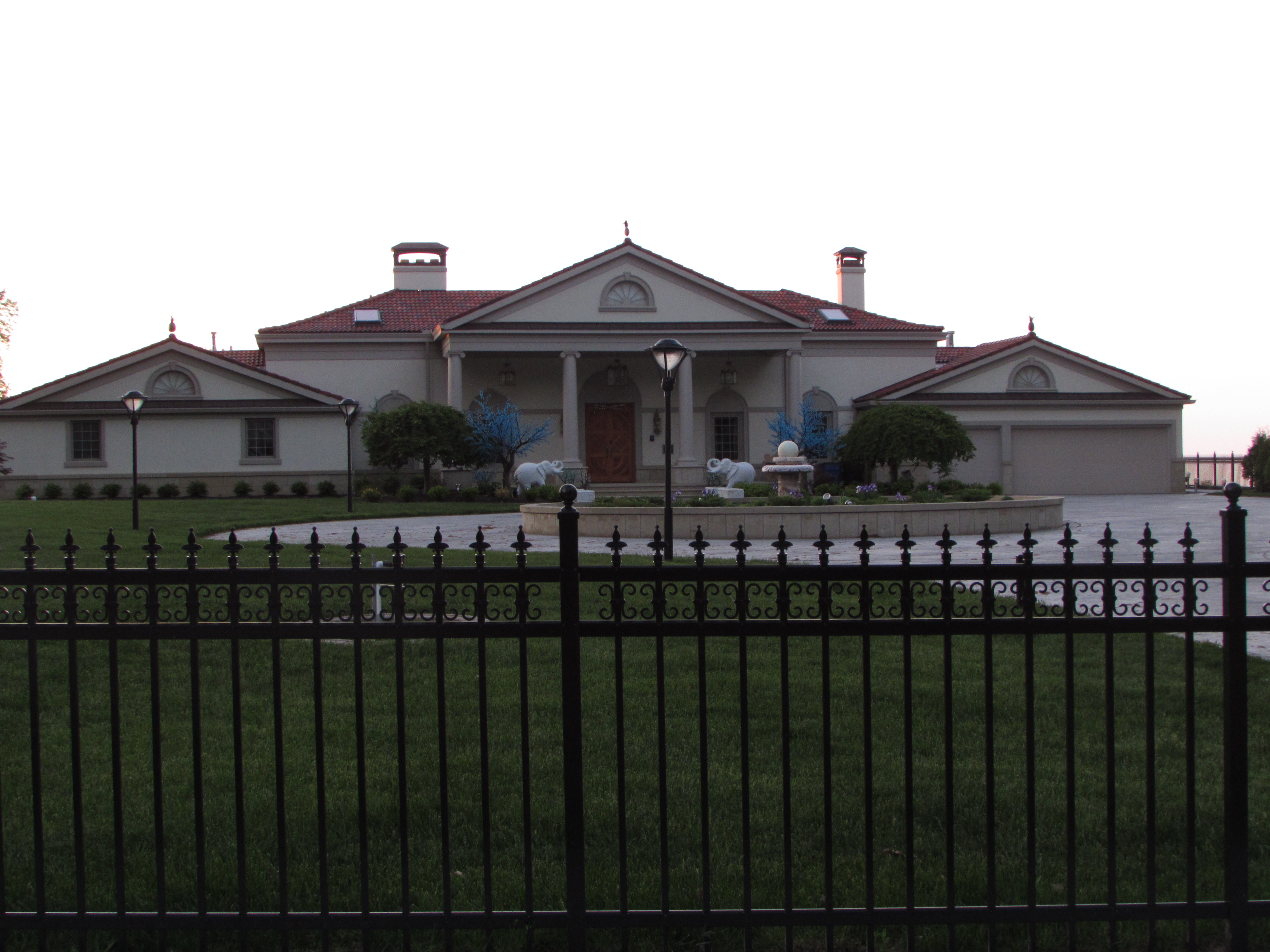 front lawn with black wrought iron rail in front and home in the back ground beautiful home on lake front lake erie in northern ohio usa.  Photo taken by Nancy K Gurish, Editor Your Health And Tech Friend Magazine, A Julialanan Production, LLC.